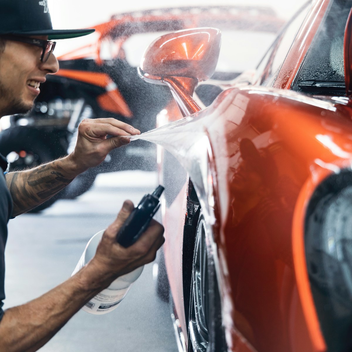 Elite detailer polishing a luxury car in a driveway
